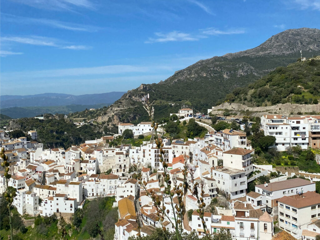 Charmerende hvid by placeret på bjergskråning under blå himmel.