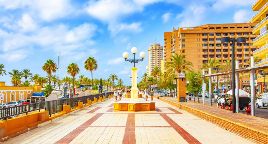 hoteller og feriestemning.|Fuengirolas solbeskinnede strandpromenade med palmer