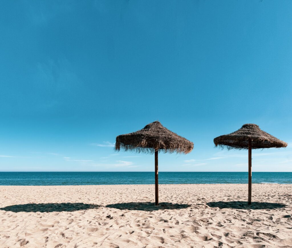 To parasoller og en uendelig horisont over Middelhavet.